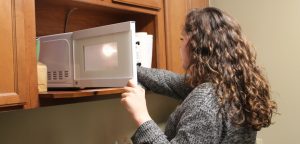student using microwave